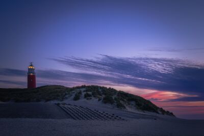 De zonsopkomst na het blauwe uurtje bij de vuurtoren op Texel