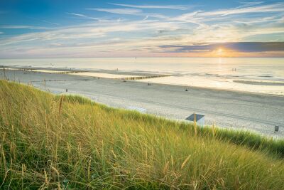 Strandlandschap aan de Nederlandse kust bij ondergaande zon