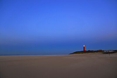 Het brede strand bij de vuurtoren van Texel bij avond