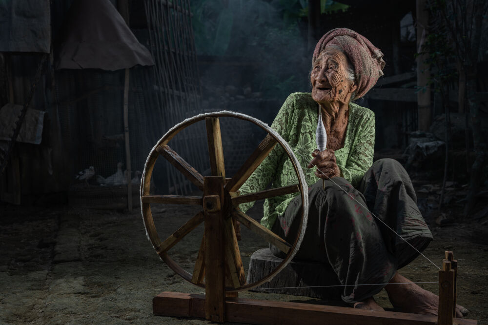 Old Balinese woman with her spinning wheel